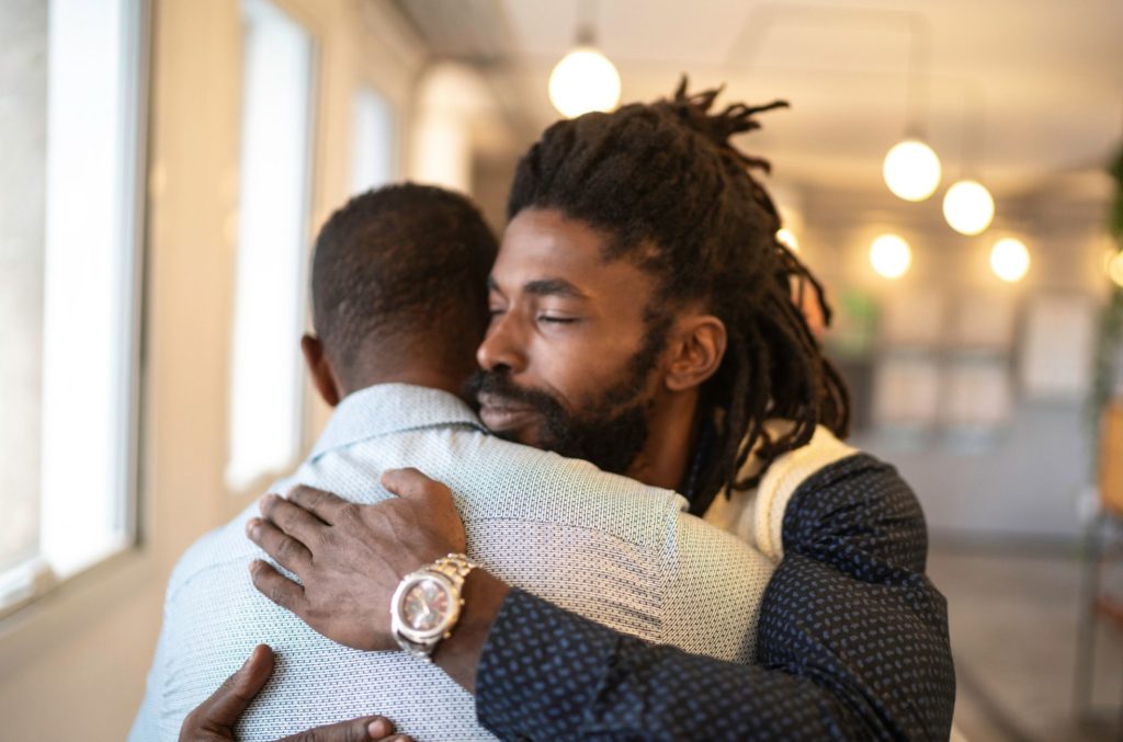 two friends hug after one learned what to say to help a depressed person