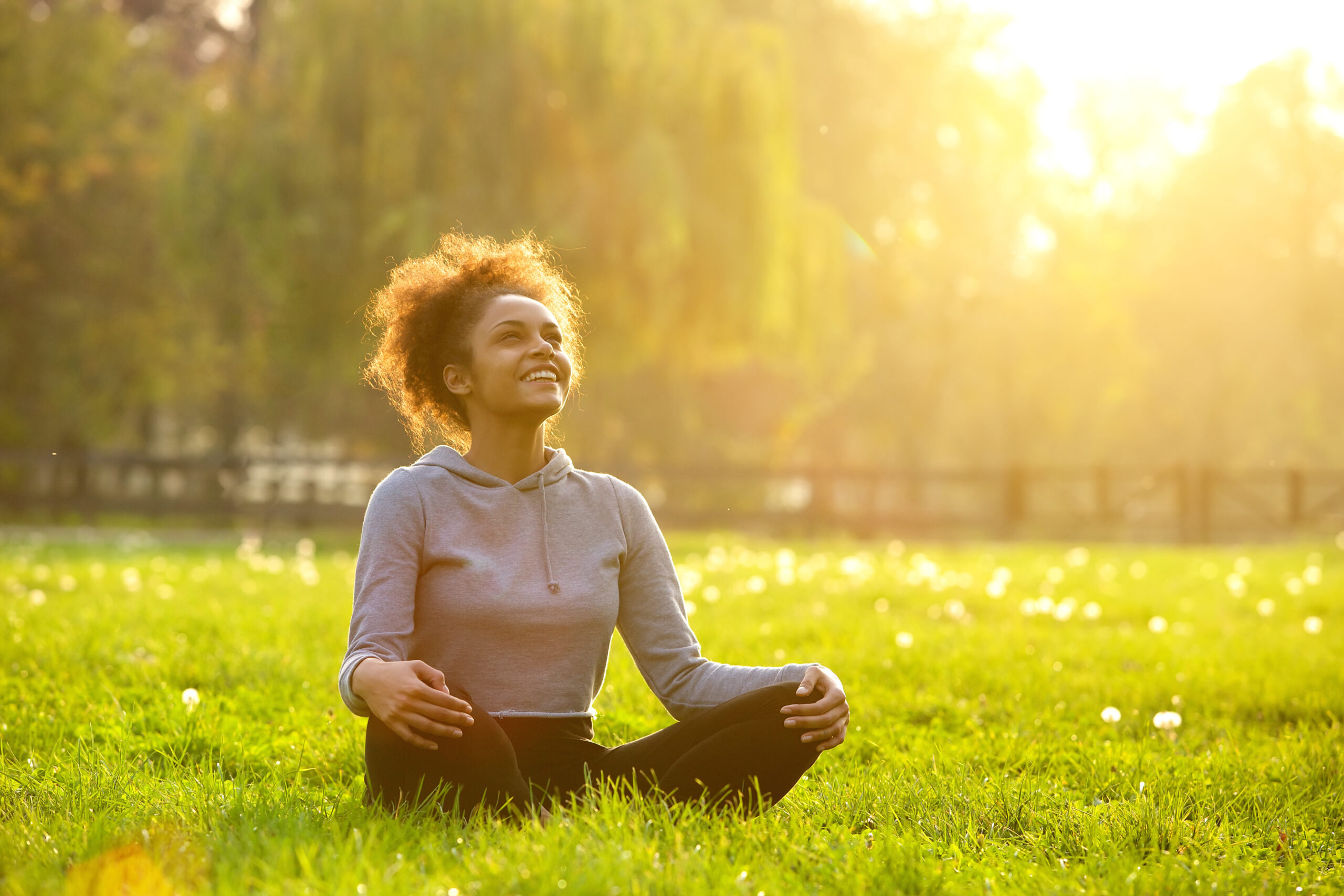 Healthy young woman performing yoga in a grassy field